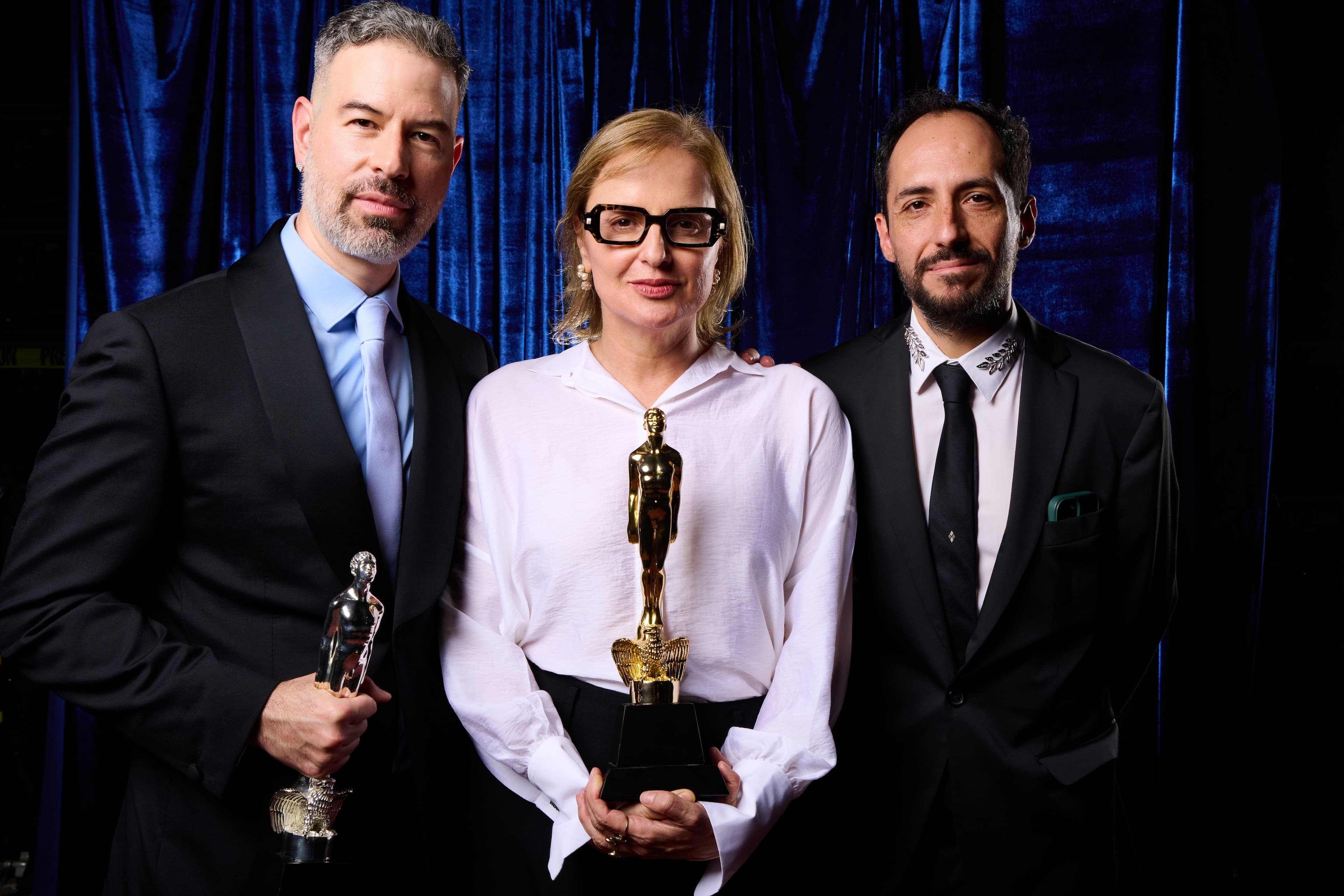 El director David Pablos y los productores Inna Payán y Luis Salinas, posan con los Ariel 2026 para 'En el camino'